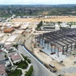 An aerial view of the early stages of construction, showing the initial framework of the arena.